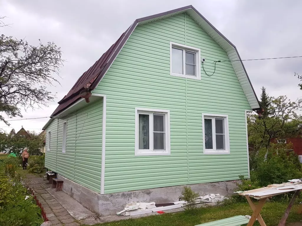 Сайдинг можно выбрать практически любого цвета, вплоть до мятно-зеленого, как на фото. И выглядеть он будет, как крашенная деревянная доска.